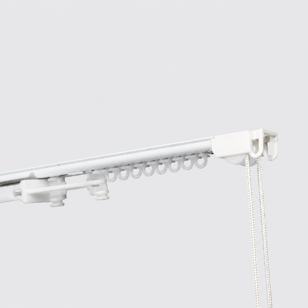 Slim cord drawn track with operating cord and gliders