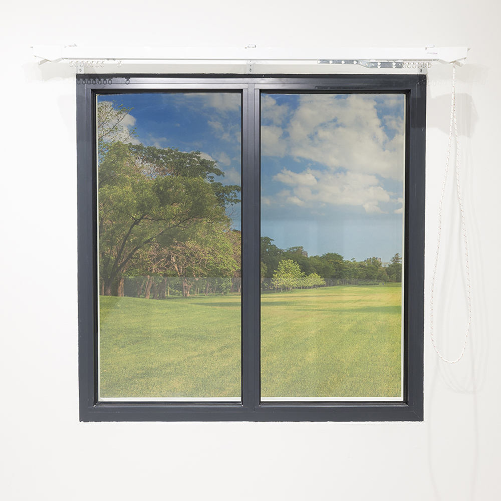 Wide curtain track installed above a window with operating cord